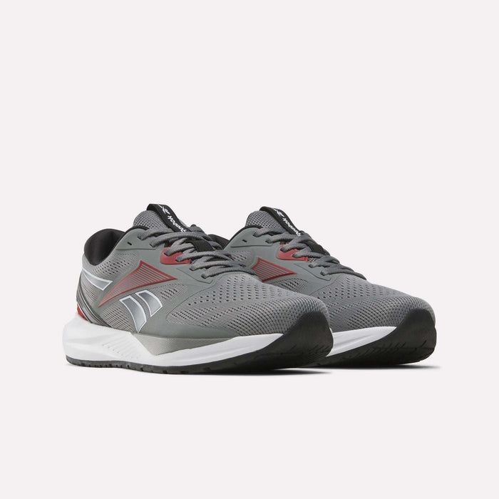 A pair of Reebok Men's Nanoflex 2 Training Shoes in gray—perfect for workouts—featuring red and white accents, breathable mesh uppers, black soles, and white midsoles, displayed on a plain white background.