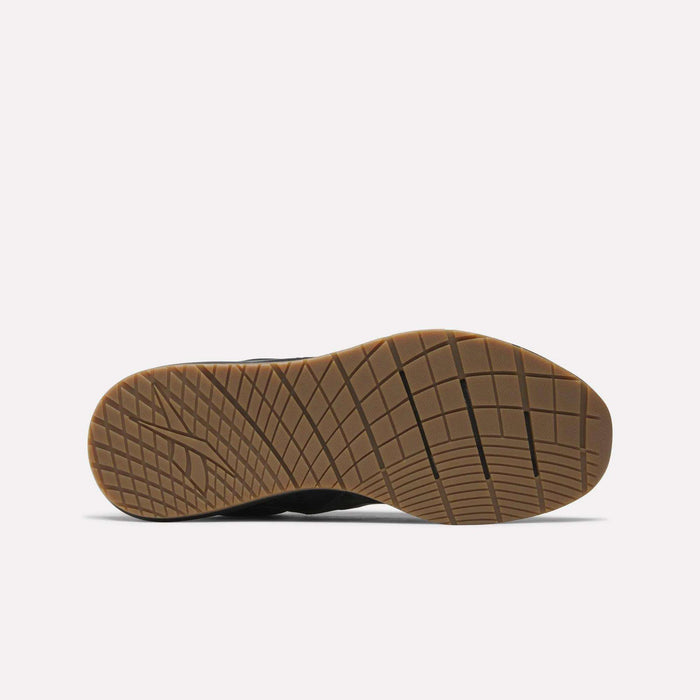 The image displays the sole of a Reebok Men's Nanoflex Trainer 2 Shoe, featuring a tan rubber bottom with a grid tread pattern, photographed against a plain white background.