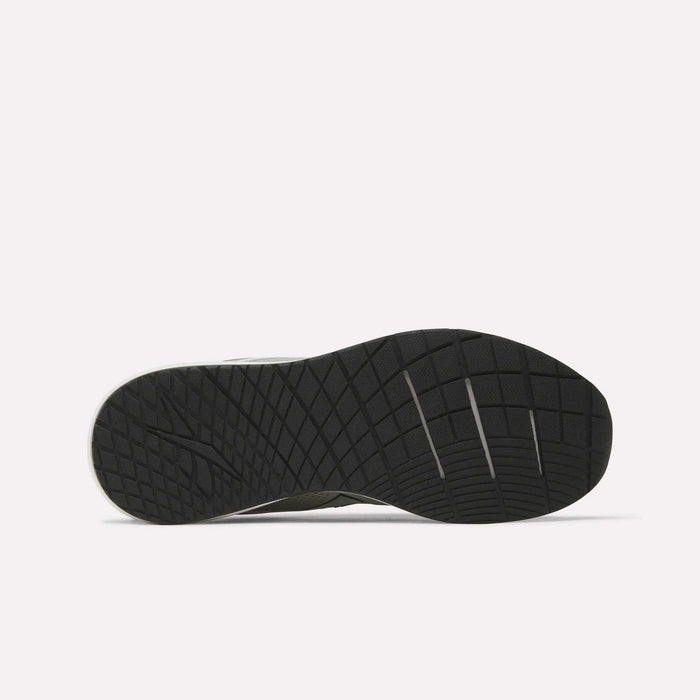The image displays the black rubber outsole of a Reebok Men's Nanoflex 2 Training Shoe, highlighting its geometric tread pattern and several horizontal flex grooves, set against a plain white background.