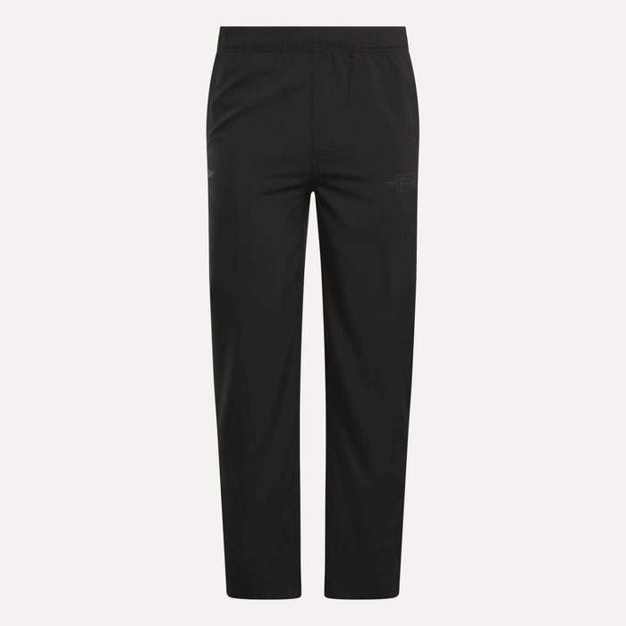 The Men's Reebok x F45 Training Woven Pants feature an elastic waistband, straight legs, and subtle stitching details, designed by Reebok for optimal performance during high-intensity training sessions. They are shown against a plain white background.