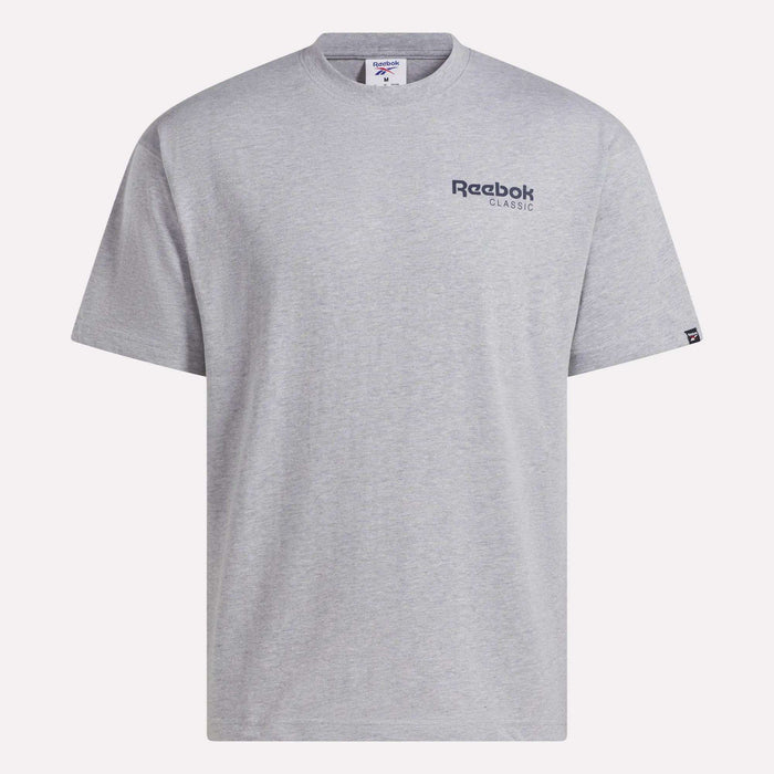 Introducing the Men’s Relaxed Logo T-Shirt by Reebok. This men’s t-shirt features a light gray color, short sleeves, and a classic crew neckline. Crafted from soft cotton fabric for everyday comfort, it displays a small navy Reebok Classic logo on the left chest. The relaxed fit makes it perfect for casual wear, and the shirt is shown laid flat against a white background.