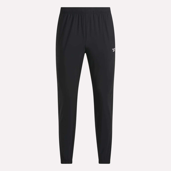 Men’s Repeat Pants by Reebok feature a black, slim-fit design with an elastic waistband and cuffs. These athletic track pants display a small white Reebok logo on the upper left thigh and are designed without visible pockets or drawstrings.