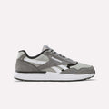 The Men’s Run LXS Shoes by Reebok, shown in the New Grey 2/Grey 4/Black colorway, feature a suede and mesh upper with full-grain leather overlays, classic white side stripes, black accents, and a thick white midsole—these retro running sneakers for men are displayed on a plain light background.