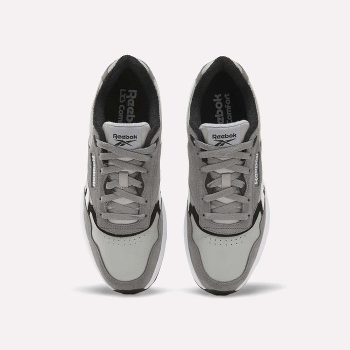 A pair of Reebok Men’s Run LXS Shoes in gray and white are shown from above, crafted from full-grain leather with visible laces, a perforated toe area, and Reebok branding on both the tongues and sides. These classic men’s sneakers feature a retro running shoe silhouette that blends timeless style with lasting comfort.