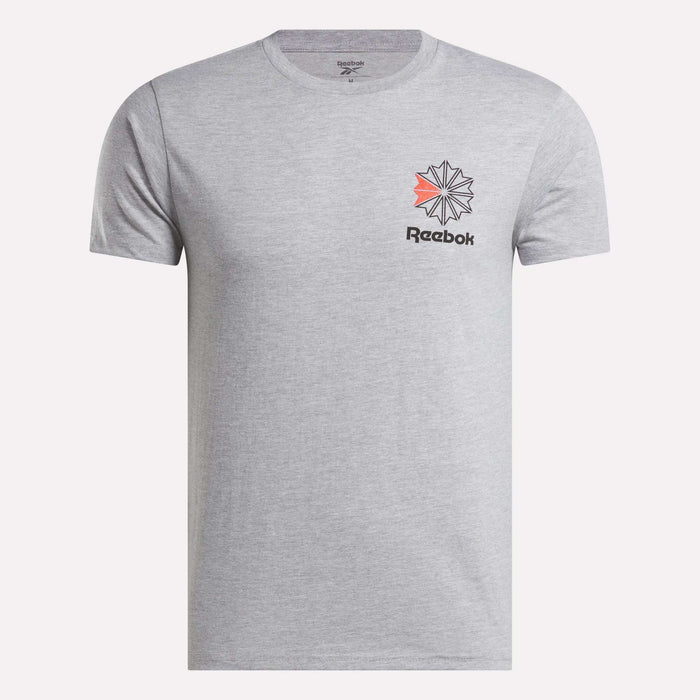 The Reebok Men's Starcrest Logo Graphic T-Shirt is light gray, made from soft cotton, and features a black Reebok logo with a red and black geometric design on the left chest. The shirt is shown on a plain white background.