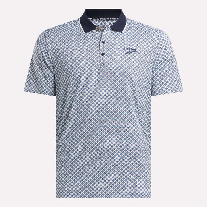 The Reebok Men's Sublimation Print Shirt features short sleeves, a blue and white geometric pattern, a dark blue collar, sweat-wicking fabric, and a small Reebok logo on the left chest.