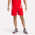 A person models Reebok Men's Train Blocked Knit Shorts, paired with a red athletic shirt and gray running shoes with red accents, against a plain white background. The head is cropped out—ideal for focusing on the workout wear.