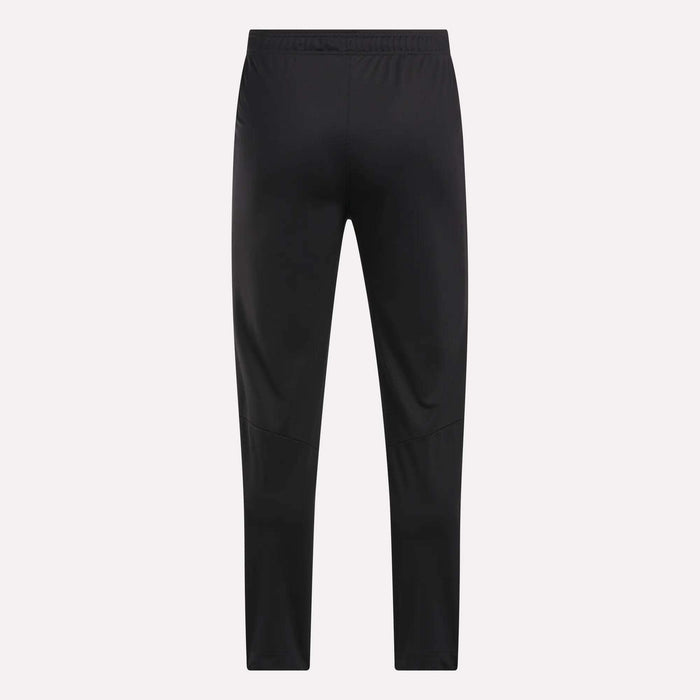Men's Train Knit Pants by Reebok shown from the back, featuring a slim fit and elastic waistband, set against a plain light background.