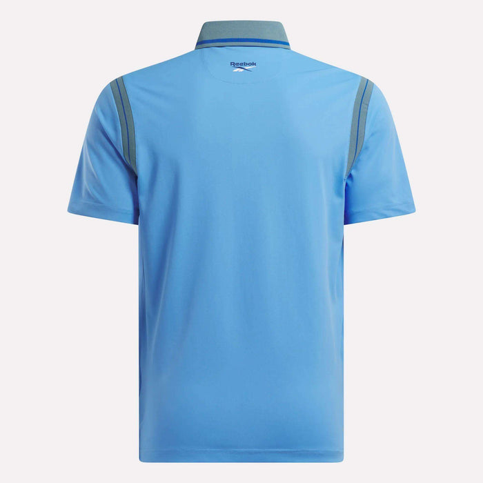 Back view of a light blue Men's Varsity Polo Shirt by Reebok featuring dark blue shoulder accents, a classic collar, and the Reebok logo below the collar—ideal for stylish comfort on or off the golf course.