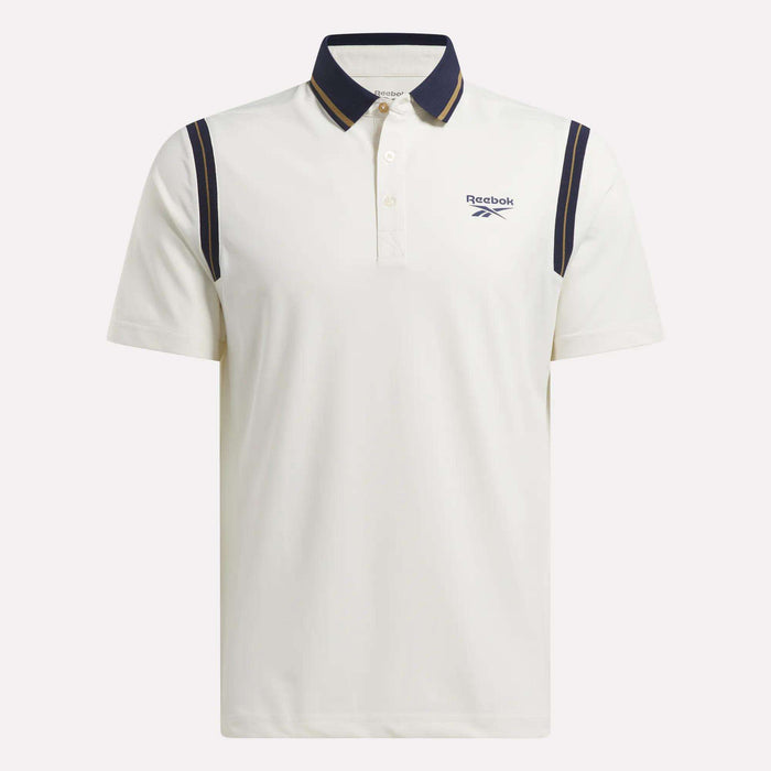 The Men's Varsity Polo Shirt by Reebok features RBK-DRY fabric for comfort, a dark blue collar and shoulder stripes, small left-chest logo, short sleeves, and button-up placket—ideal as a stylish golf polo.