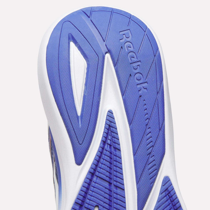 Close-up of the blue and white sole of a Men's Viva Speed Shoe by Reebok, featuring the Reebok logo and a variety of textured patterns for enhanced grip and traction—engineered for cushioned comfort and breathability.