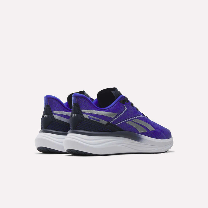 A pair of Reebok Men's Viva Speed Shoes in purple, featuring silver accents and thick, cushioned white soles, displayed from the back and side on a plain white background. These breathable shoes provide both style and comfort for active wearers.