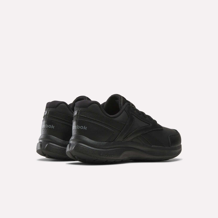 A pair of Men's Walk Ultra 7 DMX Max Shoes - Wide 4E by Reebok are displayed on a white background, angled with the heels facing the camera and toes pointing outward. These black wide-fit walking shoes feature DMX cushioning, delivering comfort and support for everyday wear.