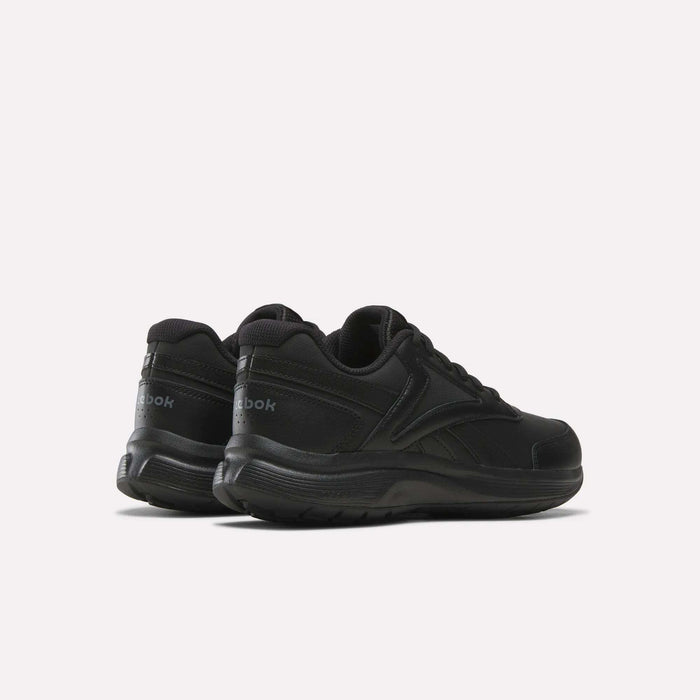 A pair of Men's Walk Ultra 7 DMX Max Shoes by Reebok in black, showcasing low-top design and DMX cushioning for enhanced comfort, viewed from the back and side on a plain light background.
