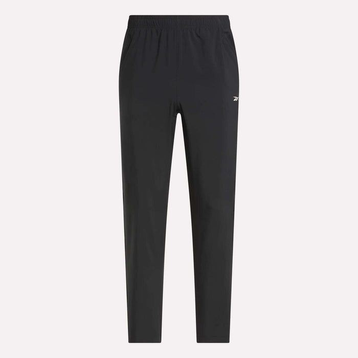 Reebok Men's Woven Pants with elastic waistband and side pockets, featuring a small white logo on the left thigh. Lightweight polyester in black, shown on a light plain background for a sleek, sporty style.