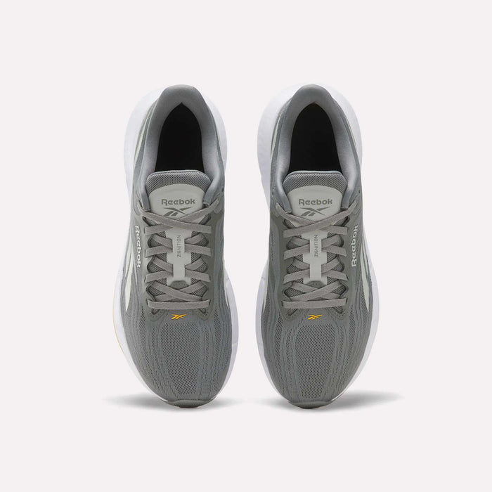 A pair of Reebok Men’s Zignition Running Shoes in gray, shown from above, featuring white midsoles and breathable mesh uppers. The Reebok logo appears on the tongue and side of each shoe. These shoes offer springy cushioning and a wider forefoot for enhanced comfort with every stride.