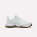 The Reebok Nano Golf Shoes feature a mesh and synthetic upper with lightweight FlexWeave, subtle Reebok branding, white laces, and a brown rubber sole. The white athletic sneakers are displayed against a plain white background.