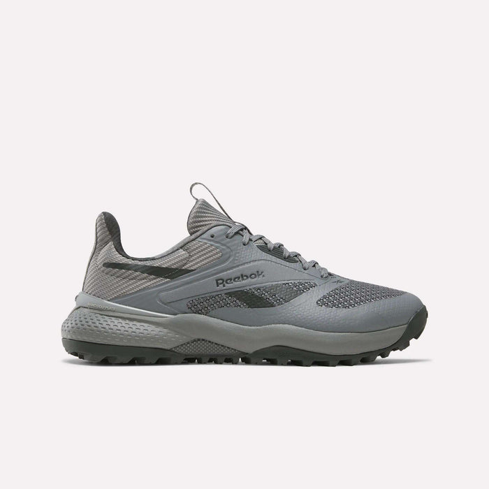 A gray Reebok Nano Golf Shoe with a lightweight FlexWeave upper, mesh and synthetic panels, lace-up closure, and a rugged textured sole is shown in side profile on a light background.