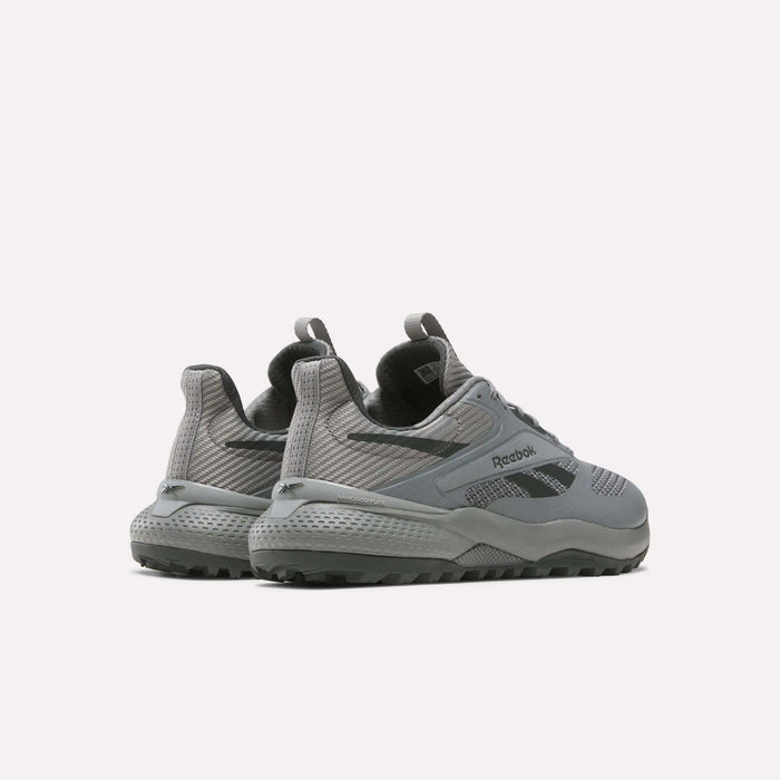 A pair of Reebok Nano Golf Shoes in gray, shown from the back and side. They have a lightweight FlexWeave mesh and synthetic upper for breathability, textured soles, and dark gray accents on a light base.