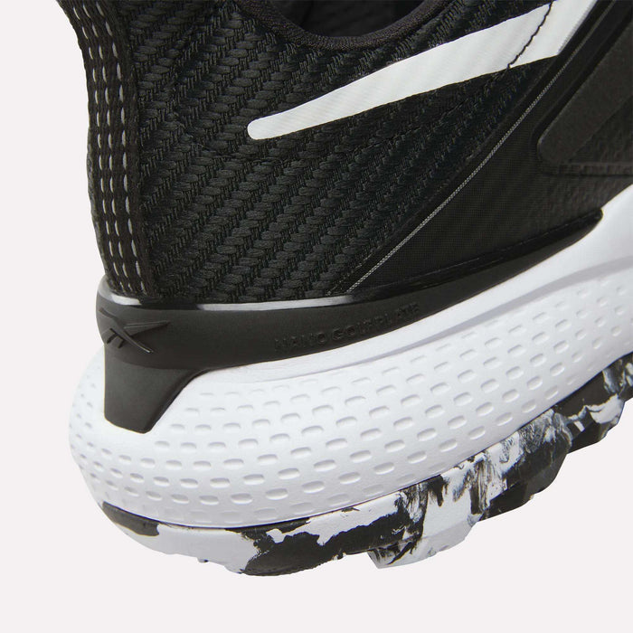 Close-up of the heel of Reebok Nano Golf Shoes, showing a black and white FlexWeave upper, a dimpled white midsole, and a black-and-white patterned outsole.