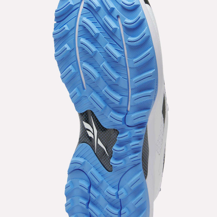 Close-up of the blue and white textured outsole on Reebok Nano Golf Shoes, featuring deep treads, carbon fiber accents, performance foam cushioning, and part of the upper.
