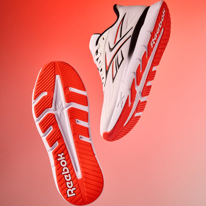 Red and white Reebok Nano Gym 2.0 training and running shoes on a gradient red background