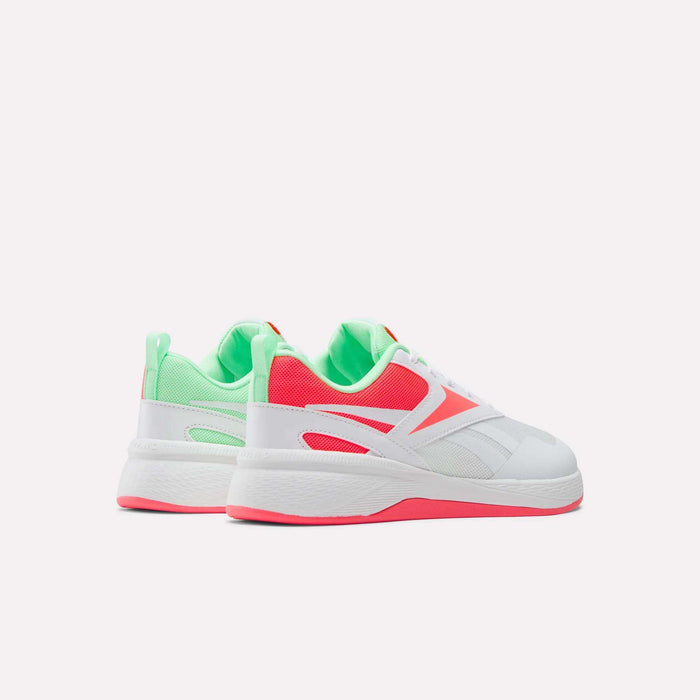 The Reebok Nano Play Shoes for little kids feature a chunky sole, mesh panels, and neon pink and green accents on white, designed as trendy girls’ trainers and shown against a plain white background.