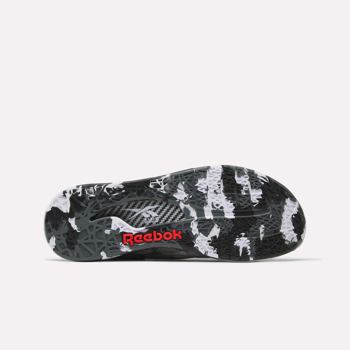 The image displays the sole of the Reebok Nano Pro Training Shoes, featuring a black, white, and gray camouflage pattern with the red Reebok logo at the center.