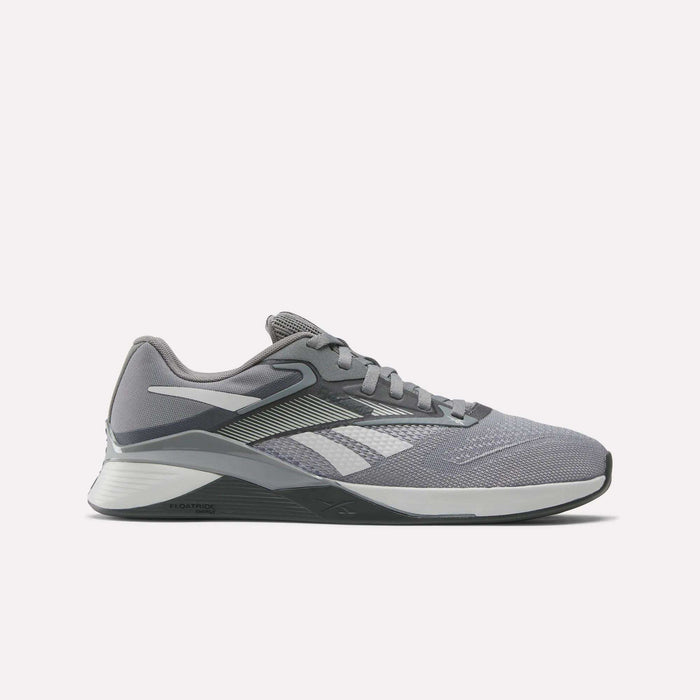 The Reebok Nano X4 Training Shoes feature a gray mesh upper with white and black accents, geometric pattern, side logo, lace-up closure, low-profile sole, and Floatride Energy Foam for enhanced comfort and support.
