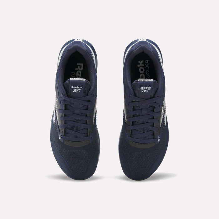 Top view of a pair of Reebok Nano X4 Training Shoes in navy blue, featuring white soles and side logos, crafted with Flexweave material, displayed on a plain light background.