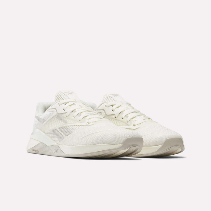 The Reebok Nano X4 Training Shoes are off-white, lightweight trainers with breathable mesh uppers, lace-up closures, and textured soles, shown angled to the right on a plain white background.