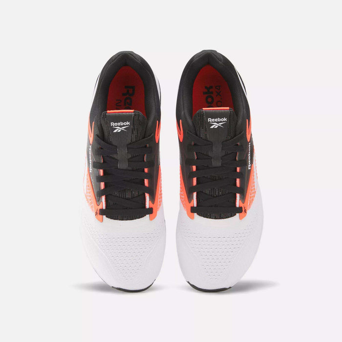 A pair of Reebok Nano X4 Training Shoes, seen from above, with white mesh toes for breathability, black laces and tongues, black heels, and orange side accents.