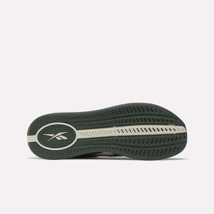 The image shows the green and beige rubber outsole of the Reebok Nano X4 Training Shoes, featuring an oval Reebok logo near the heel, a textured tread for grip, and lightweight Floatride Energy Foam cushioning.