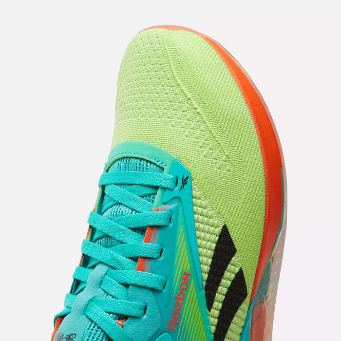 Close-up of Reebok Nano X4 Training Shoes with a yellow-green mesh upper, turquoise laces and tongue, orange accents, black diagonal stripes, and the Reebok logo on the side.