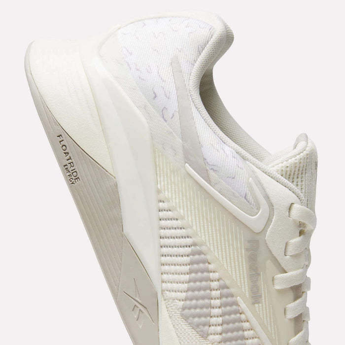 A close-up of Reebok Nano X4 Training Shoes in off-white, featuring breathable mesh panels, textured fabric, laces, and "FLOATRIDE" on the midsole. The shoe's modern design ensures a lightweight feel for training sessions.