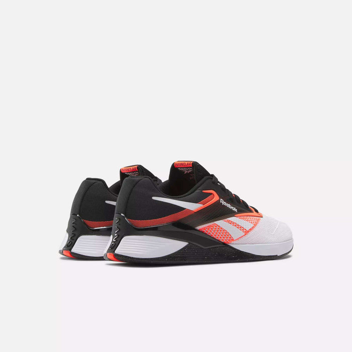 The Reebok Nano X4 Training Shoes in black, white, and bright orange feature breathable mesh details, a white midsole, and Reebok logos on the sides, displayed against a plain white background.
