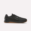 The Reebok Nano X5 Edge Training Shoes in black feature a low-profile, lace-up design with a Flexweave upper, subtle logo, and brown rubber sole—ideal for precision training. Shown against a plain white background.