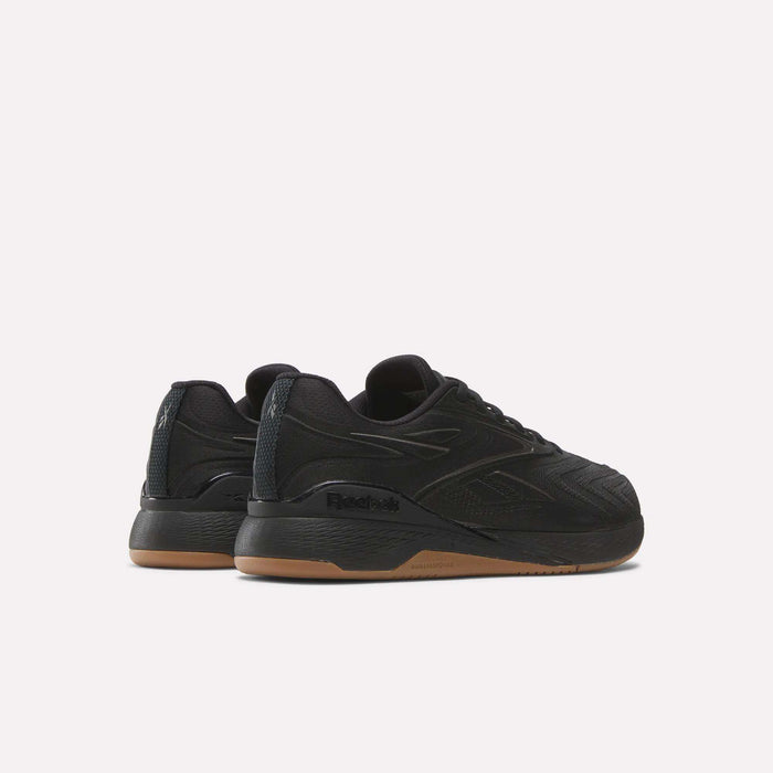 A pair of black Reebok Nano X5 Edge Training Shoes with gum soles is displayed from a rear-side angle on a white background, featuring Flexweave textured details and Reebok logos on the sides and heel.