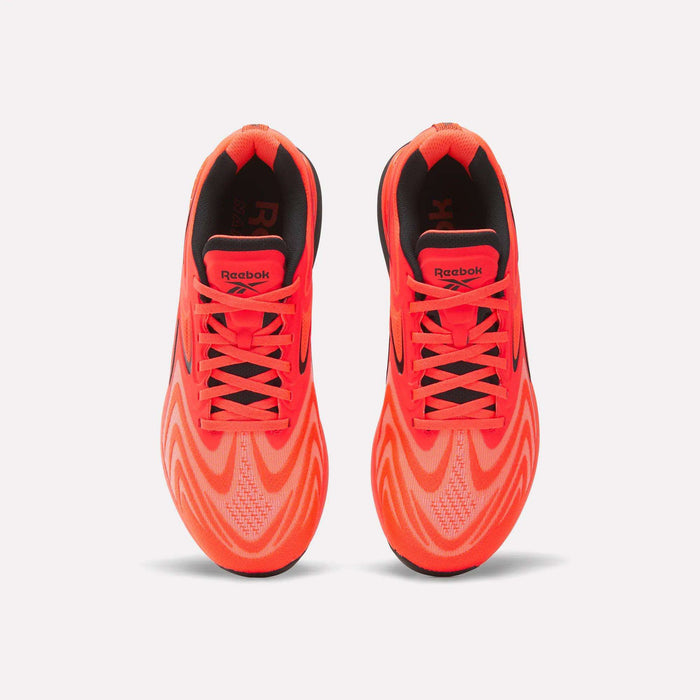 A pair of Reebok Nano X5 Edge Training Shoes in bright orange is viewed from above, highlighting the laces, Reebok logo on the tongue, and a wavy pattern on the mesh uppers designed for enhanced performance.