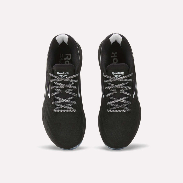 Top view of a pair of Reebok Nano X5 Edge Training Shoes in black, featuring white and gray laces, white logo detailing on the tongue, and white accents near the heel—all set against a plain white background. Engineered by Reebok for peak performance during your toughest workouts.