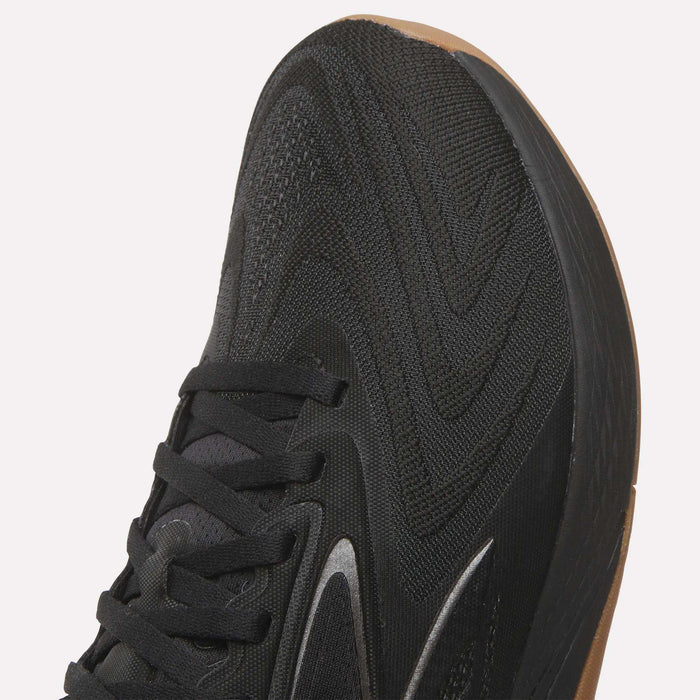 Close-up of the toe and laces of Reebok Nano X5 Edge Training Shoes, showcasing a textured Flexweave mesh upper, thick light brown rubber sole, wave-like patterns, and subtle reflective accents.