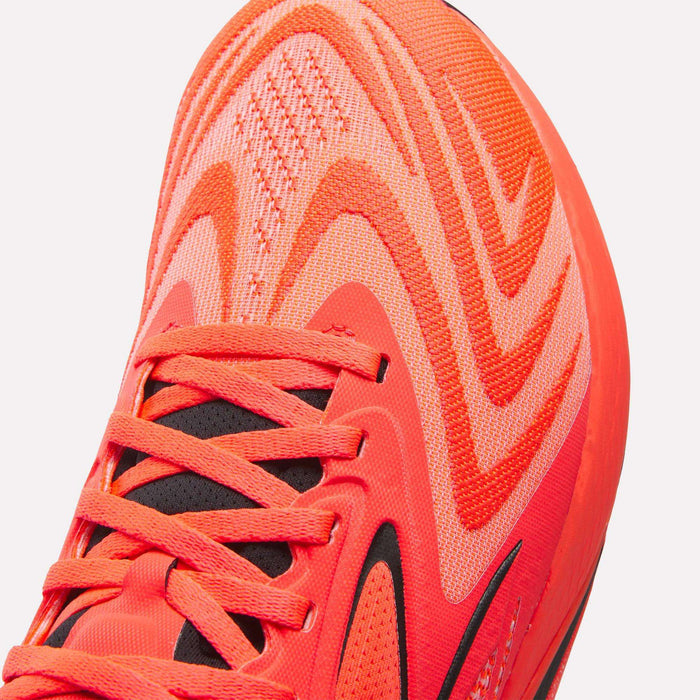 Close-up of the front of the Reebok Nano X5 Edge Training Shoes in bright orange, featuring wavy patterns, black detailing, and matching orange laces—engineered for peak performance.