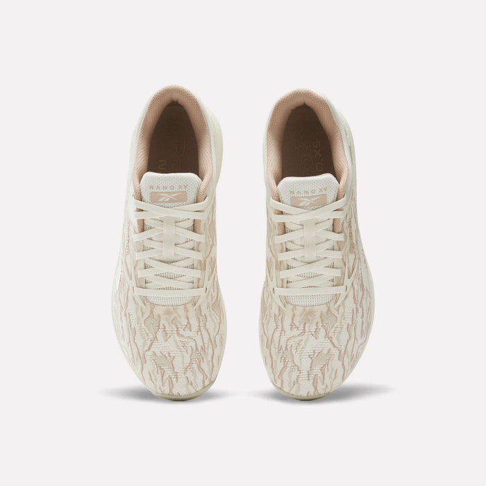 A pair of beige Reebok Nano X5 Training Shoes for men, seen from above, with subtle wavy patterns, light-colored laces, and a comfortable inner lining.