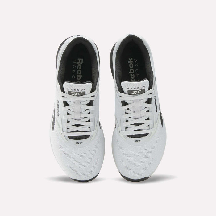 A pair of white Reebok Nano X5 men's training shoes with black accents, viewed from above, showcasing the laces, mesh upper, and Reebok branding on the tongues and sides.