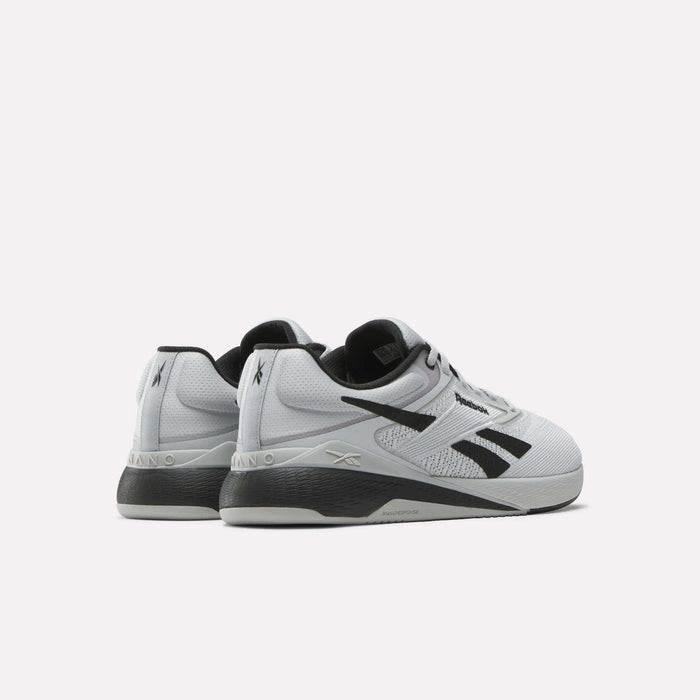 The Reebok Nano X5 Training Shoes—white with black accents and branding—are shown from the rear and side on a plain light background, making them ideal men's athletic sneakers for both style and performance.