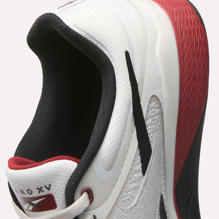 Close-up of a white Reebok Nano X5 Training Shoe with black and red accents. The heel features a red textured detail, black and red lining inside, and a visible Nano X5 label on the tongue.