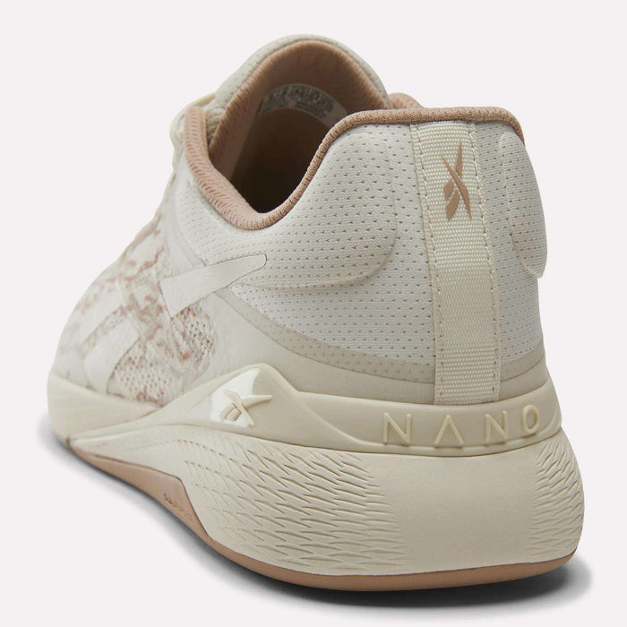 The Reebok Nano X5 Training Shoes for men in beige and cream feature a textured sole, breathable mesh upper, and branding on the heel and side; shown from back and side views, perfect for comfortable runs.