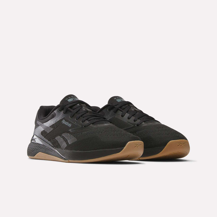 A pair of Reebok Nano X5 Training Shoes in black with mesh uppers, gray accents, and gum-colored soles, shown on a white background.