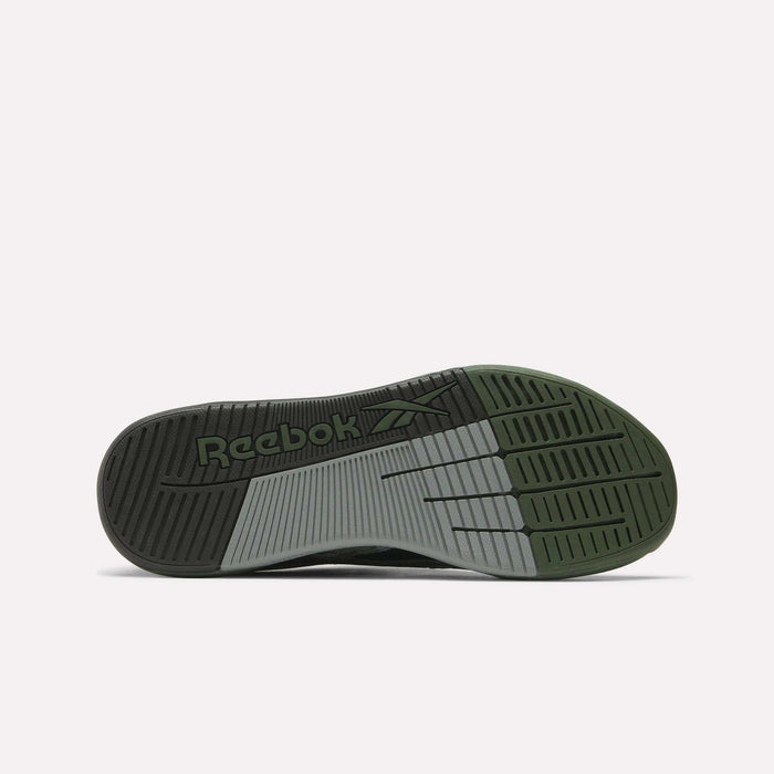 Bottom view of the Reebok Nano X5 Training Shoes outsole, showcasing black, gray, and olive green sections with grooves and an embossed Reebok logo near the heel.