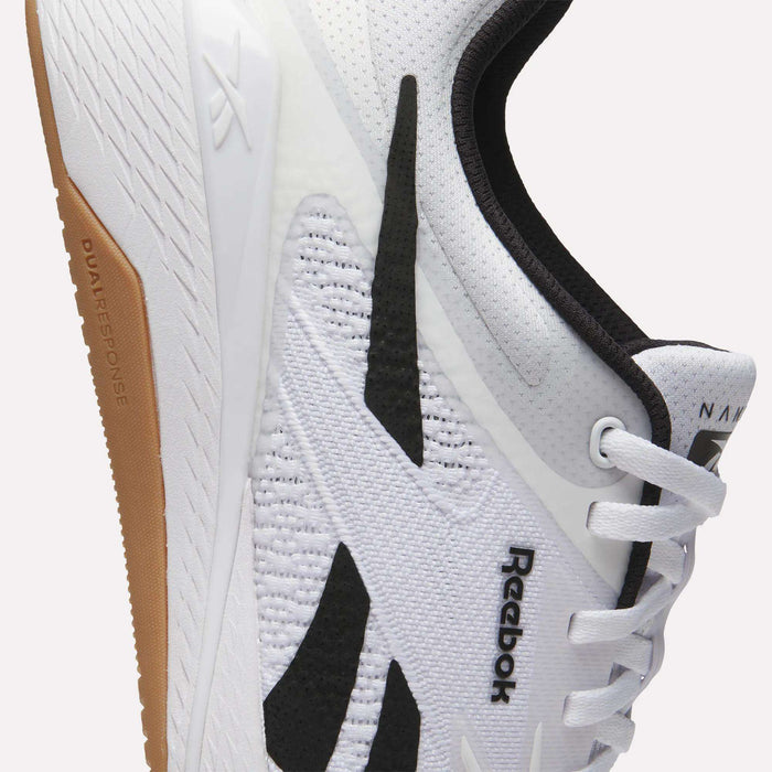 Close-up of white Reebok Nano X5 Training Shoes with black accents, white laces, and a light brown rubber sole. The Reebok logo appears on the mesh upper near the laces, showcasing these comfortable training shoes.